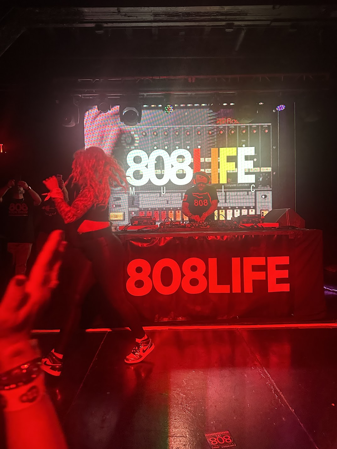Performer crossing the dancefloor in front of the 808 Life stage